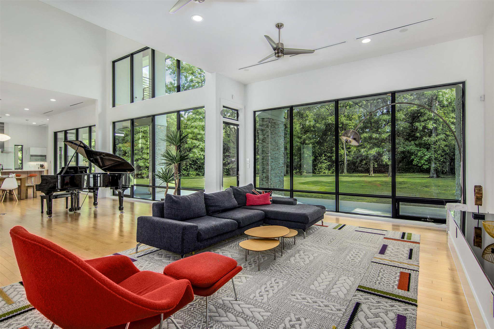 Living room with large windows looking into green foliage